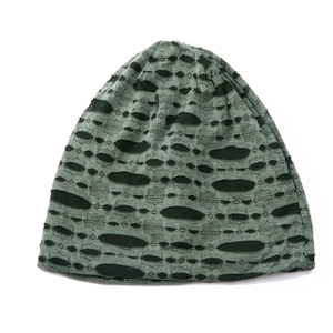 Detailed view of dark green knit beanie featuring a distressed ripped hole texture design