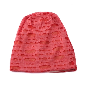Macro detail of red knitted beanie with distressed hollowed-out fabric and soft inner lining