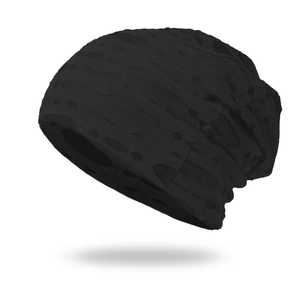 Detailed close-up of a black distressed knit slouchy beanie with stylish open hole design