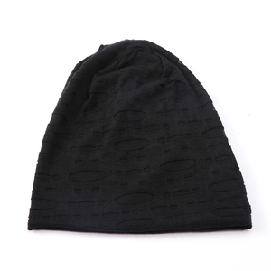 Close-up of black knitted slouchy beanie with horizontal distressed hollow-out detailing
