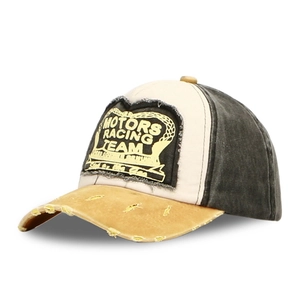 Detail of vintage racing baseball cap with distressed yellow brim and MOTORS embroidery