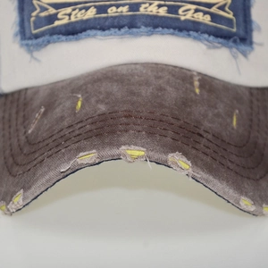 Detailed macro view of distressed denim visor with Step on the Gas embroidery patch