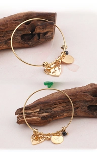 Detailed macro view of Mother's Day gold bangle with heart charm and engraved pendant