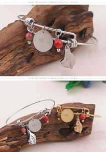 Detail of gold and silver heart bracelets with 'I love you' charms on natural wood