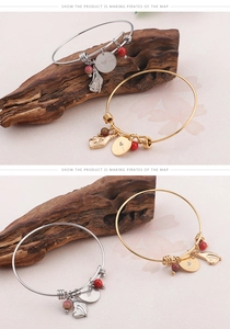 Detail of gold and silver charm bracelets with I Heart You engraving and red bead charms