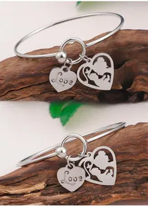 Detail of silver heart pendants with Love engraving and mother-child hollowed-out motif