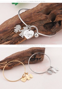 Détail de bracelets minimalistes en acier titane avec pendentifs cœur Love, garçon et fille