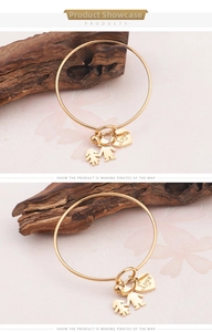 Détail macro du bracelet en acier titane doré avec breloques garçon, fille et cœur Love