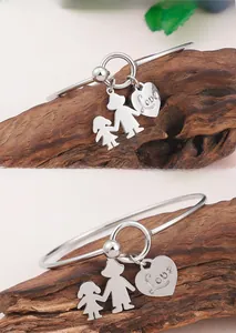 Détail du bracelet en acier argenté avec cœur Love et pendentif silhouette mère et fille