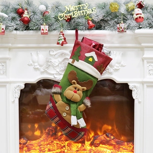 Red Christmas stocking with 3D reindeer hanging on a mantelpiece above a warm fireplace