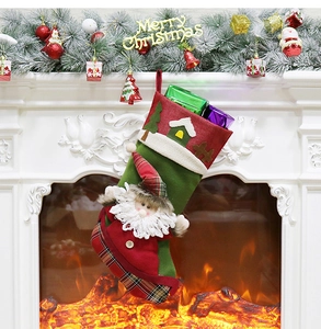 Christmas stocking with Santa doll hanging by a cozy fireplace with festive decorations