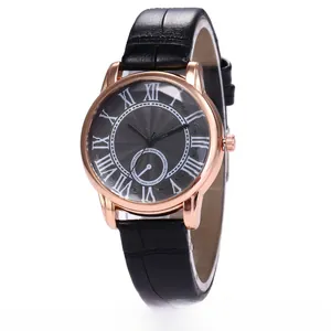 Macro detail of rose gold watch case with black Roman numeral dial and leather strap