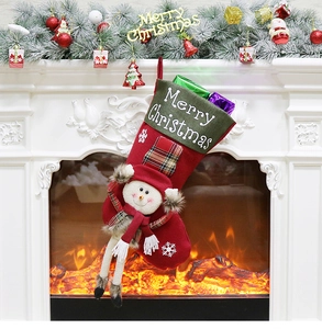 Gros plan d'une chaussette de Noël rouge et verte avec bonhomme de neige sur une cheminée