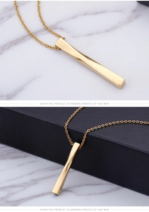 Macro detail of golden twisted bar pendant on stainless steel chain necklace
