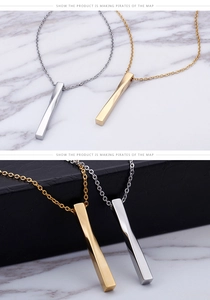 Macro detail of twisted bar pendant in gold and silver finish with cross chain