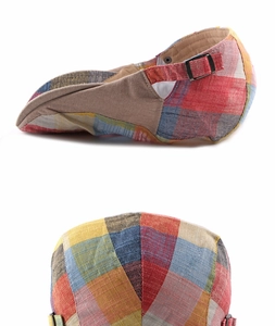 Close-up of colorful plaid flat cap showing metal buckle and woven cotton texture