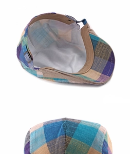 Detailed view of colorful plaid flat cap with adjustable metal buckle and inner lining