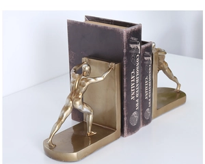 Detail of golden human figurines bookends showing creative movement and metallic texture