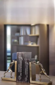 Close-up of golden athletic male bookends showing detailed muscle texture and metallic finish