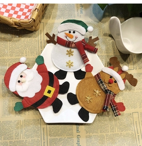 Detail of felt Santa Snowman and Reindeer decorations placed on a white ceramic plate
