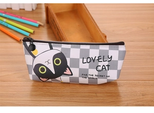 Détail d'une trousse à carreaux avec chat de dessin animé sur fond de bois