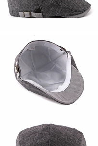 Detail view of dark grey flat cap featuring textured fabric and metal buckle