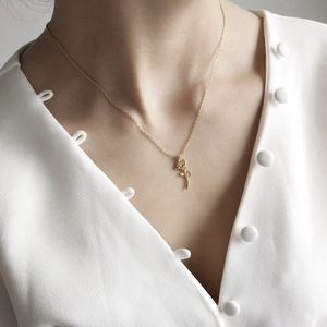 Model wearing a delicate rose flower pendant necklace in 925 silver with a gold finish