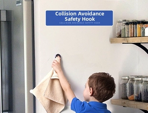 Child hanging towel on a safe black wall hook in a kitchen setting with soft lighting