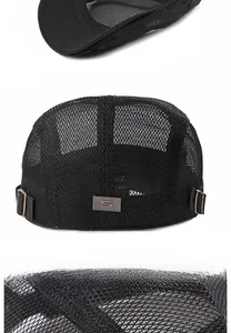 Detail of black mesh flat cap featuring breathable fabric and silver S-logo metal plate