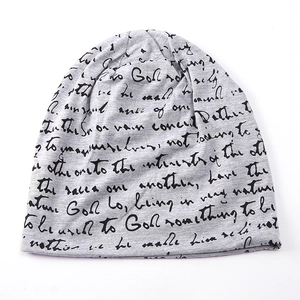 Detailed view of grey knit beanie fabric featuring black artistic cursive script printing