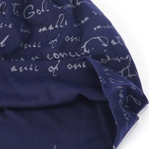 Detail of navy blue knitted beanie featuring decorative silver cursive script print