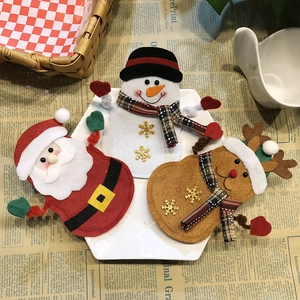 Three Christmas cutlery holders featuring Santa, snowman and reindeer on a white plate