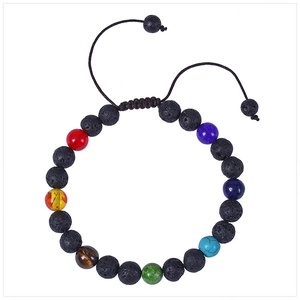 Détail macro des perles de lave de 8mm et des sept pierres chakra sur bracelet tressé