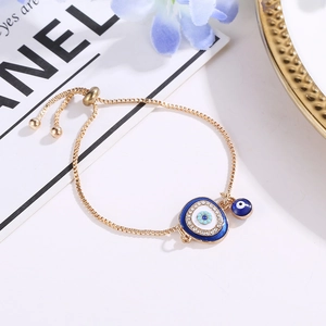 Close-up of adjustable golden Evil Eye bracelet with sparkling blue crystals and box chain