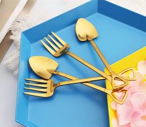 Detailed close-up of golden shovel-shaped stainless steel spoons and forks set