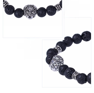 Macro detail of 8mm black lava stone beads and silver lion head charm on the bracelet