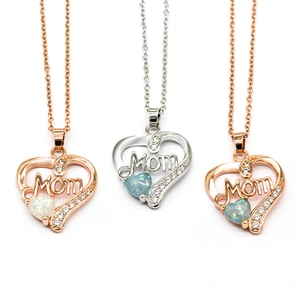 Macro view of heart-shaped MOM pendants with opal and zircon in silver and rose gold
