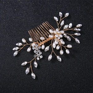 Detail of handcrafted bridal hair comb with gold wire, white pearls and clear crystals