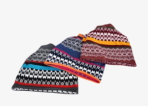 Detailed view of three knitted multi-use beanies with colorful wave and stripe patterns