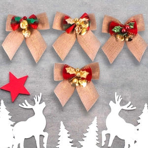 Detail of four brown burlap Christmas bows with bells, holly, and red berries on a festive table