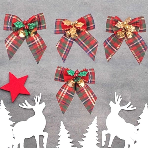 Detail of red and green plaid Christmas bows with golden bells and felt star ornaments