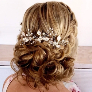 Detailed back view of a bride wearing a white leaf hair pin with pearls and rhinestones