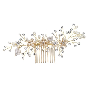 Detailed macro of bridal hair comb with gold wire, white pearls and floral enamel leaves