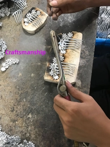 Detailed close-up showing the intricate floral metal design of the silver ponytail hair comb