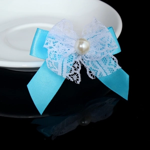 Close-up of blue satin and white lace bow hair accessory with central pearl embellishment