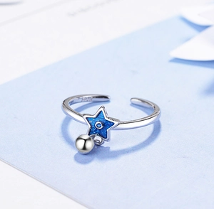 Detail view of S925 sterling silver ring featuring blue star and silver ball charms