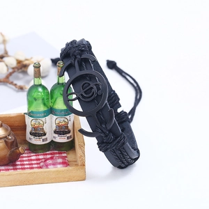 Braided black leather musical note bracelet with metal charm on white background