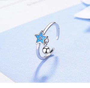 Detail of 925 sterling silver ring with blue star charm and small silver bead pendant