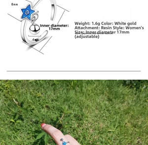 Detail of adjustable star ring with blue enamel effect and small silver bell pendant
