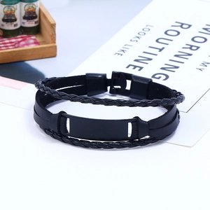 Detail of multi-layer black braided leather bracelet with rectangular metal plate